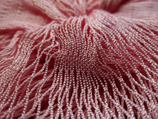 A close-up shot showing the fabric texture of a SHEIN garment, with visible loose threads and uneven stitching. The photo should emphasize the low-quality materials and poor construction of the clothing.