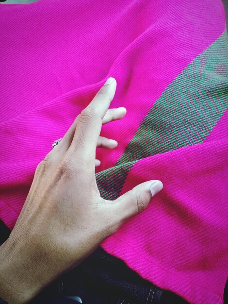 A hand touching the fabric of a SHEIN dress, focusing on the texture and weave of the material. The lighting is soft, highlighting the details and quality of the fabric.
