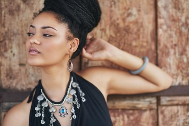 A close up shot of a woman wearing several chunky necklaces and statement earrings from SHEIN. The jewelry is gold and silver, and the woman's makeup is natural and glowing.