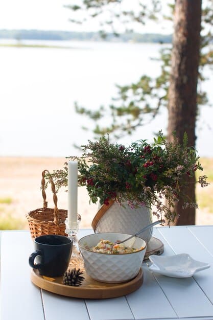 A balcony table set with candles, a small vase with flowers, and decorative objects from SHEIN, creating a charming outdoor setting.