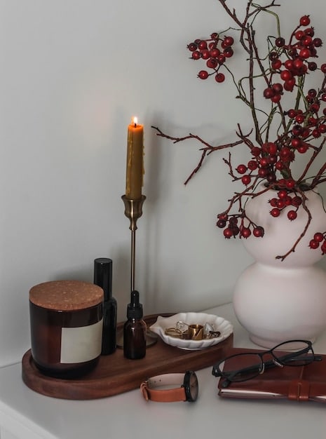 A variety of affordable SHEIN home decor items displayed on a small bookshelf: candles, artificial plants, decorative bookends, and small storage baskets. The arrangement is stylish and functional, showing how to personalize a reading nook without spending a lot.