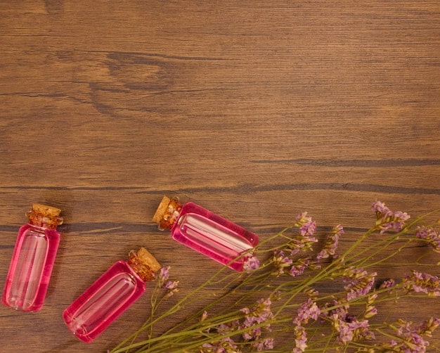 A close-up shot of a variety of essential oil bottles from SHEIN, arranged on a wooden surface with natural light. The focus is on the labels and the colors of the oils, conveying quality and variety.