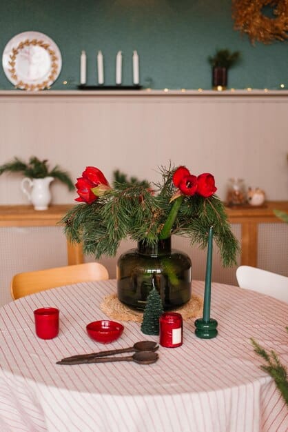 A dining table set for a Christmas dinner, decorated with affordable SHEIN decorations, including a tablecloth, napkins, and centerpieces. The setting showcases a festive and elegant dining experience.