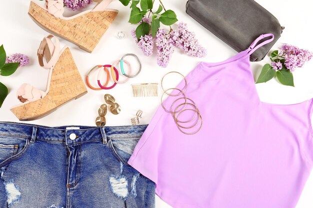 A close-up shot of various SHEIN Plus Size clothing items laid out on a light-colored surface. The items include a vibrant floral dress, a pair of denim jeans, a pastel-colored blouse, and a patterned skirt. The focus should be on the textures and colors of the fabrics, showcasing the variety and quality of SHEIN's Plus Size clothing line.