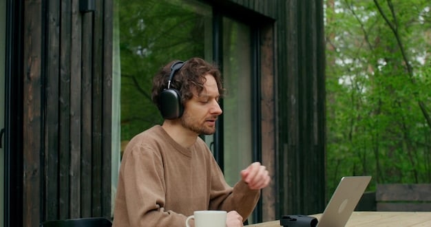 A person wearing wireless earbuds with active noise cancellation while working on a laptop in a busy coffee shop, showcasing the benefit of noise reduction in a crowded environment.