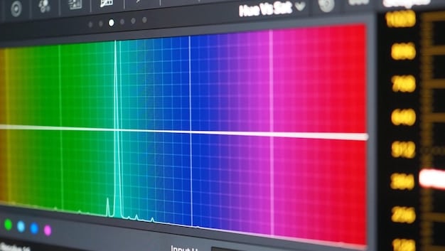 Close-up of a color calibration device attached to a professional monitor. The screen displays a color chart used for calibration.