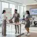 Profesionales diversos en un entorno de oficina moderno, mostrando moda de oficina reinventada para el trabajo híbrido en 2026.